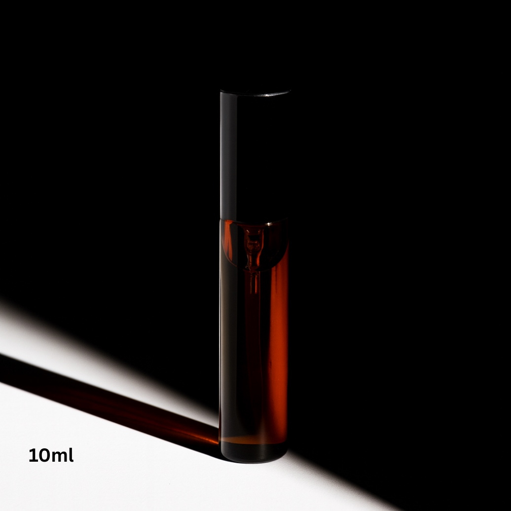 Small glass bottle with dark liquid on a black and white background