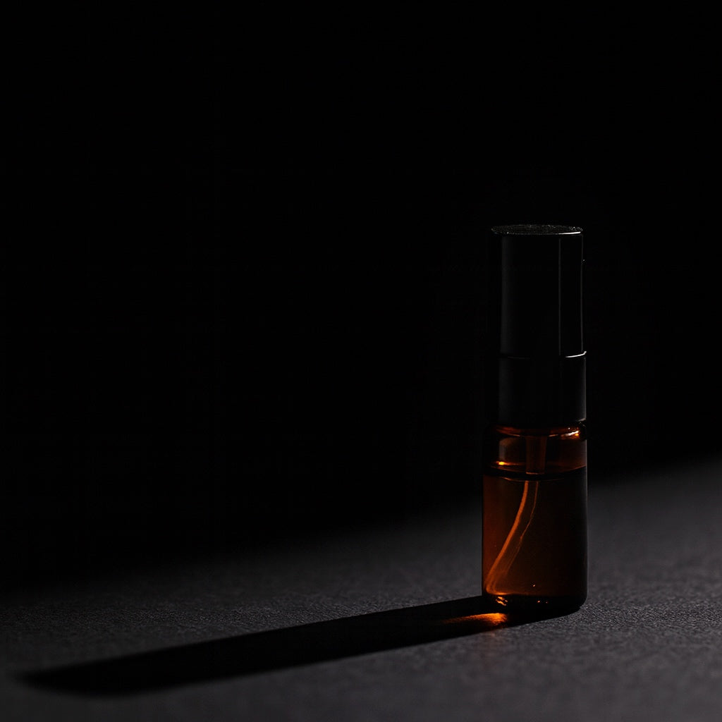 Dark glass bottle with a black cap on a black background
